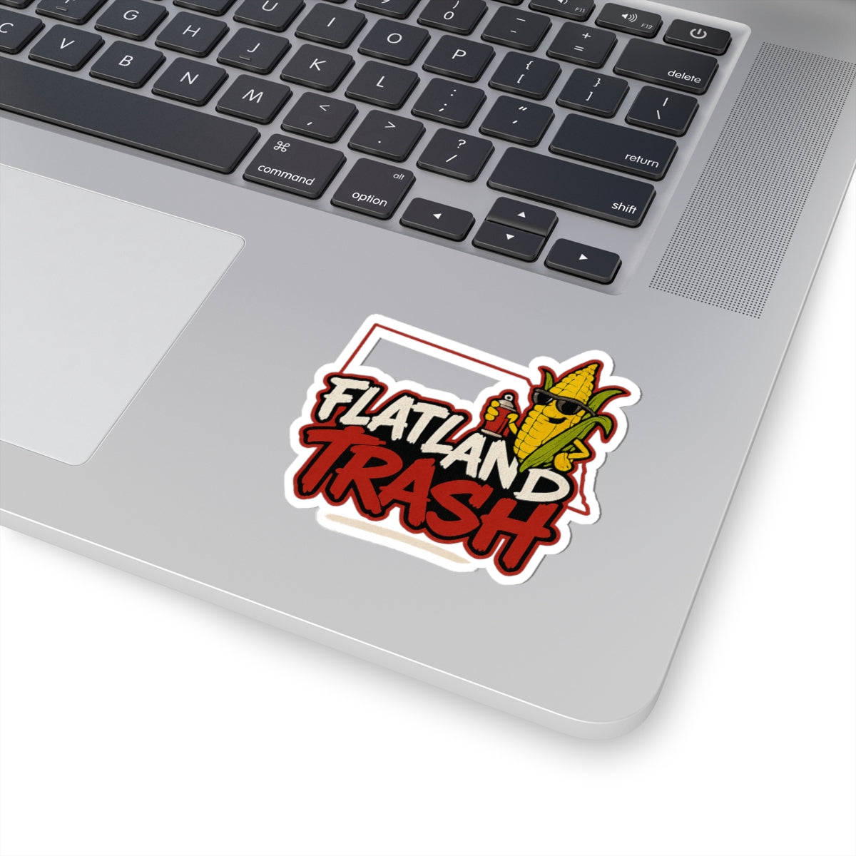 Laptop with a 'Flatland Trash' sticker on the palm rest area