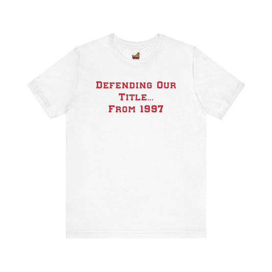White t-shirt with red text 'DEFENDING OUR TITLE... FROM 1997' on a white background